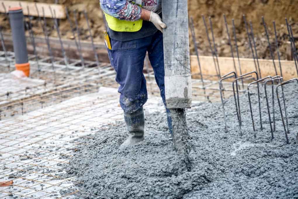 Image: Contractor applying concrete on construction site.